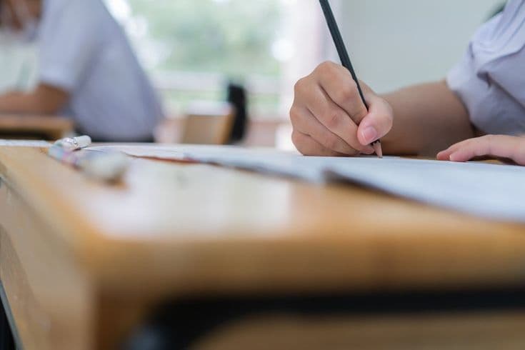 student taking notes on a notebook at school